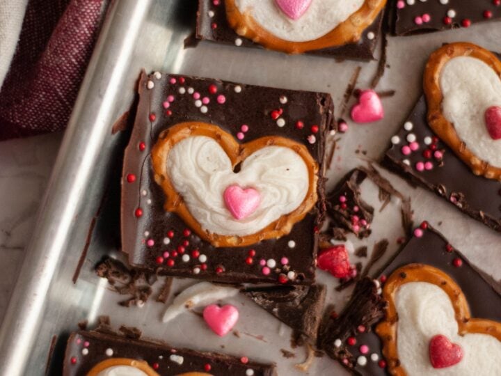 Valentine's day chocolate covered pretzels on a baking sheet.