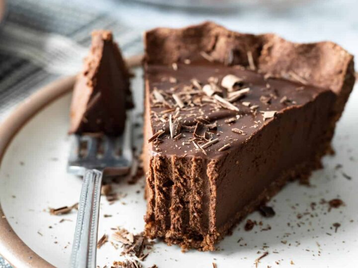 A slice of chocolate pie on a plate with a fork.
