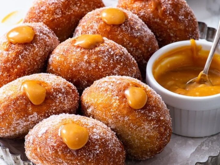 Donuts with caramel sauce on a plate.