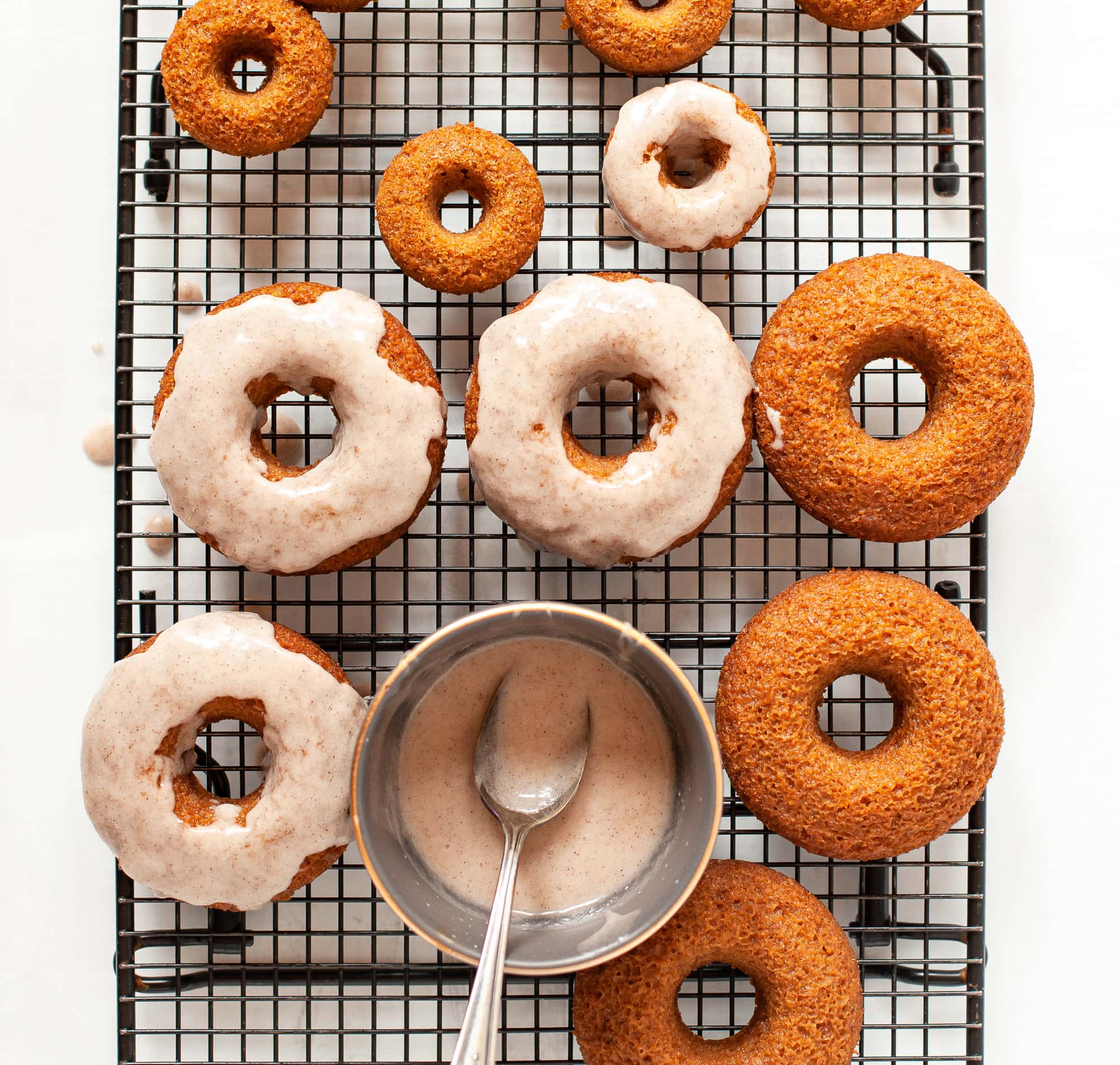 overhead photo of gluten free pumpkin spice donuts with cinnamon glaze. 