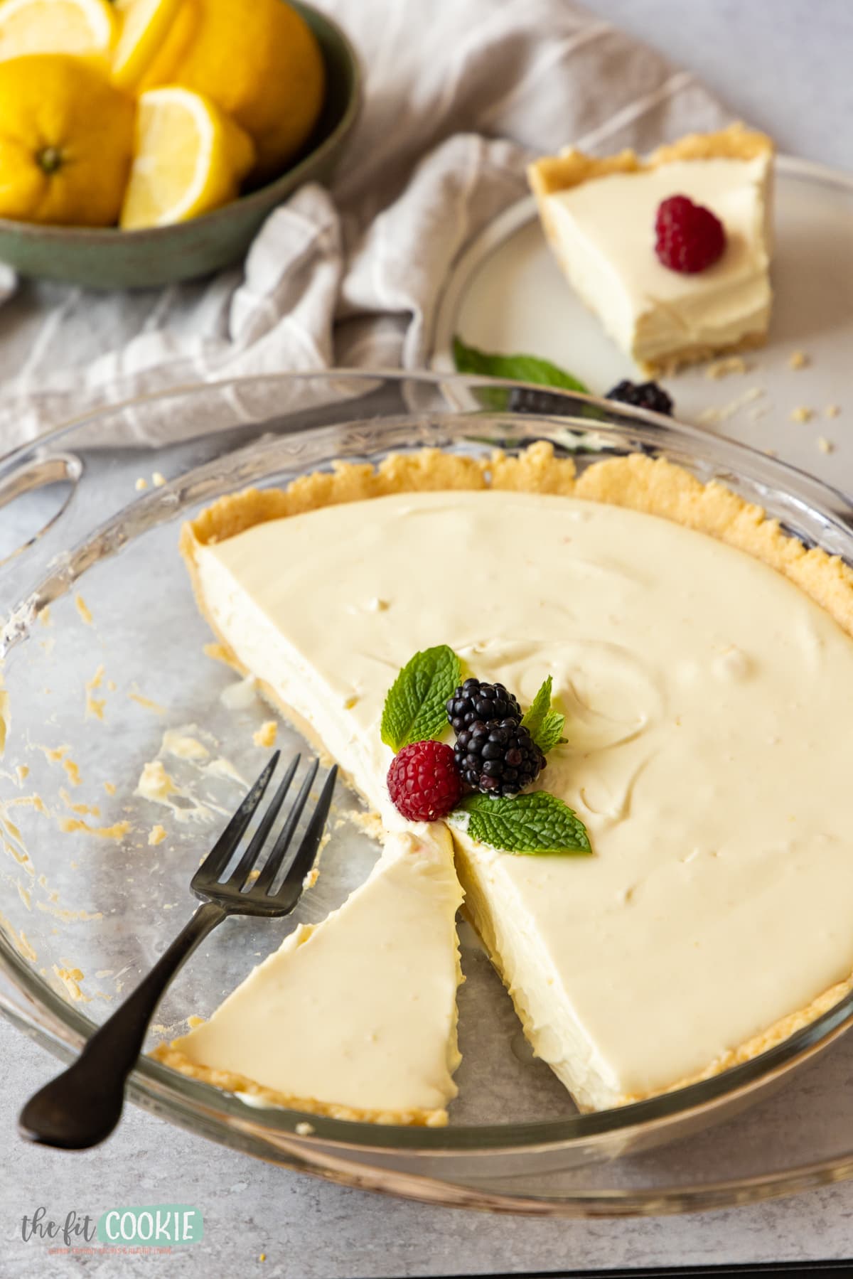 close up photo of dairy free no bake lemon cheesecake in a glass pie pan. 