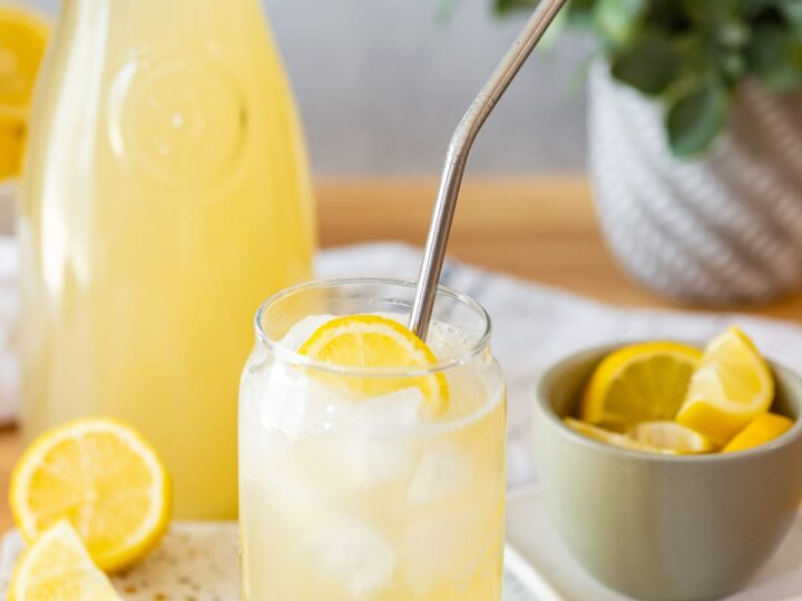 Soursop lemonade served in a glass with lemon slices.