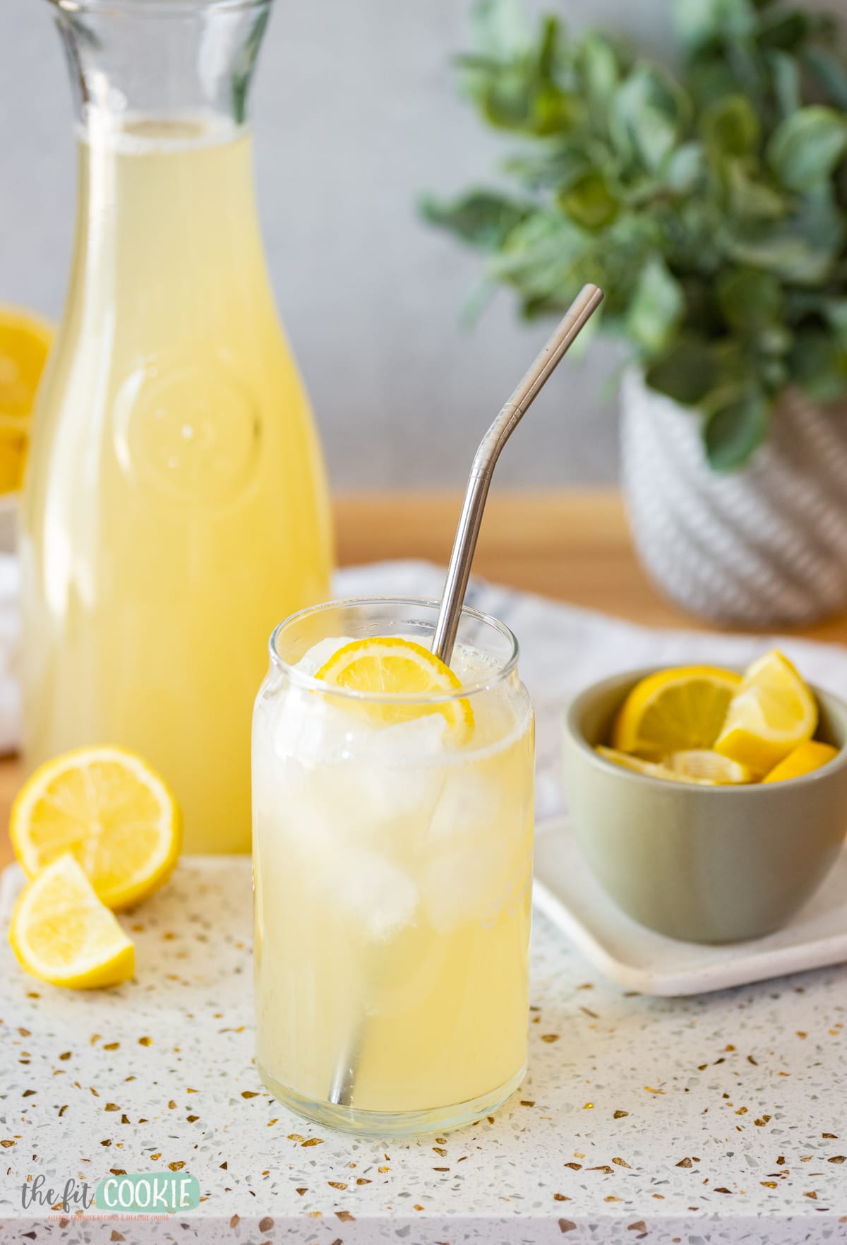 Soursop lemonade served in a glass with lemon slices.