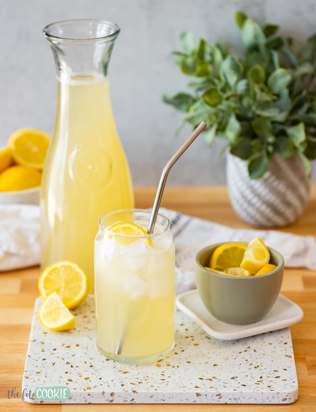 glass filled with ice and lemonade on a terrazzo-style board. 