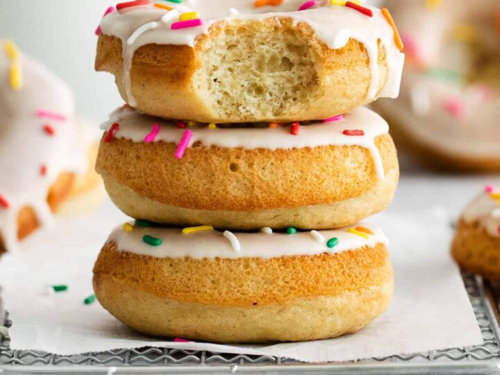 A stack of donuts with sprinkles and icing.