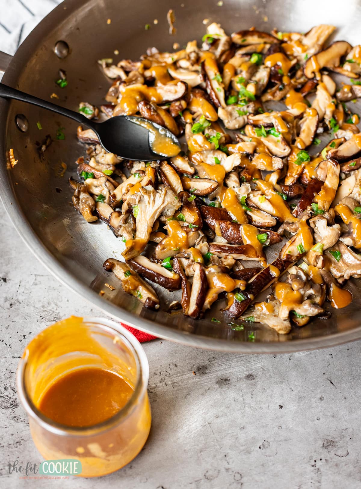 stainless steel pan filled with sauteed mushrooms drizzled with miso sauce. 