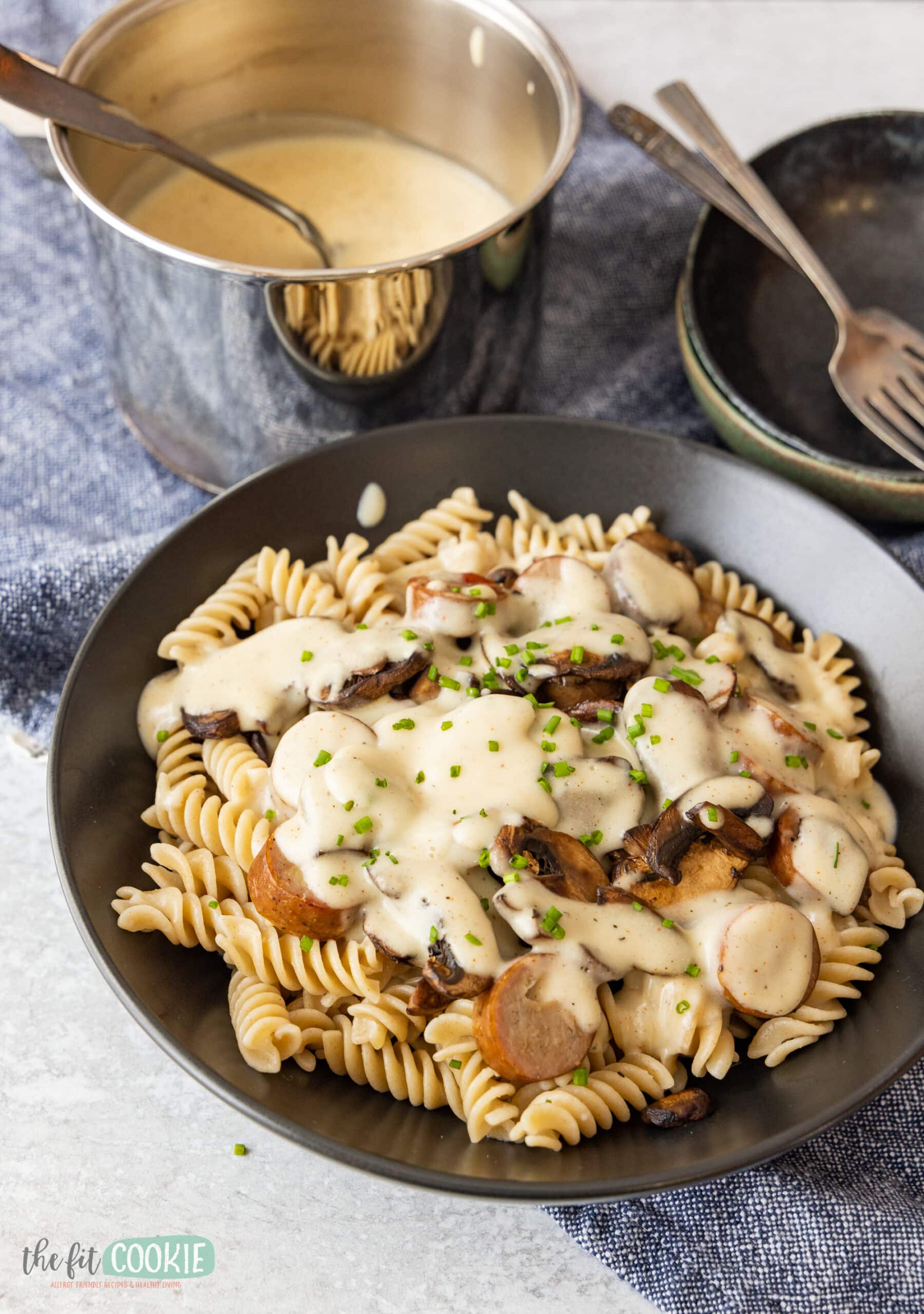 sausage and mushroom dairy free pasta alfredo in a black bowl. 