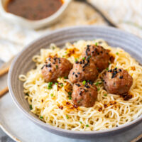 A bowl of pork meatballs with sauce.