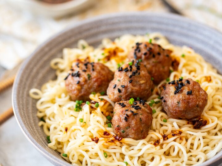A bowl of pork meatballs with sauce.