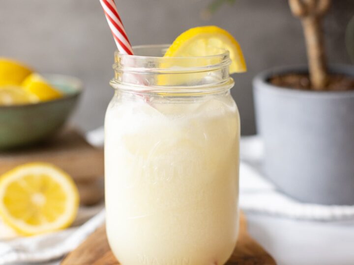 Brazilian lemonade served in a mason jar with a straw.