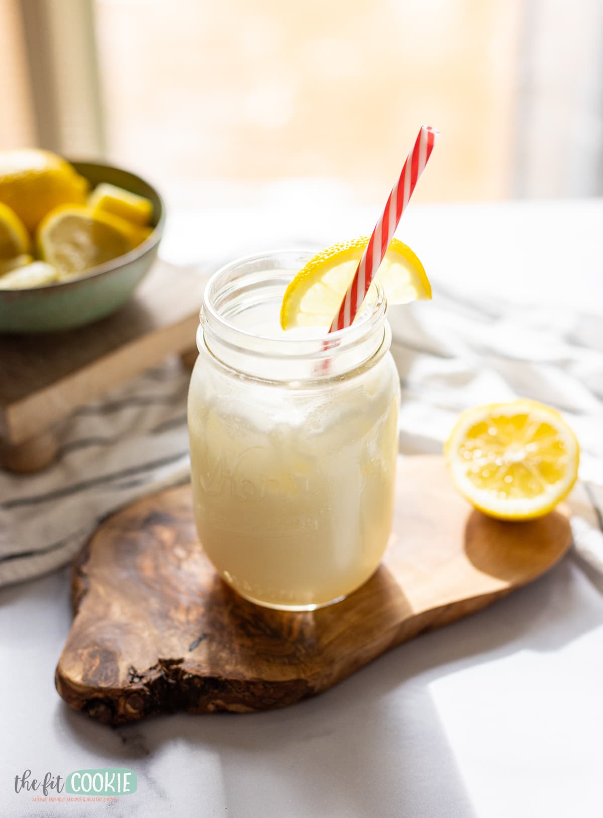 glass jar filled with brazilian lemon lemonade on a wood board.