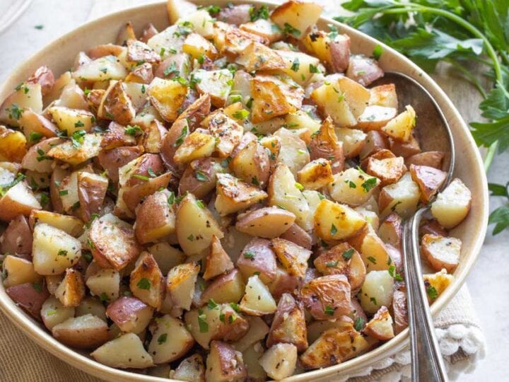 Roasted potatoes in a bowl with parsley.