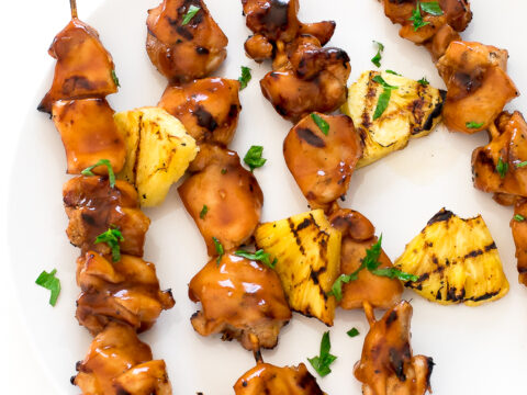 Hawaiian chicken skewers on a white plate.