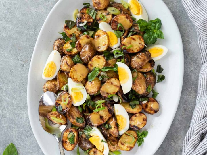 A plate with potatoes, eggs and herbs.