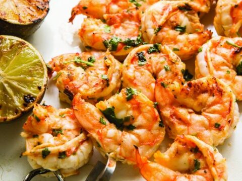 A plate of shrimp and limes.