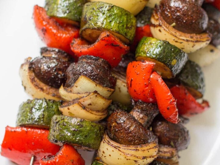 Skewered vegetables on a white plate.