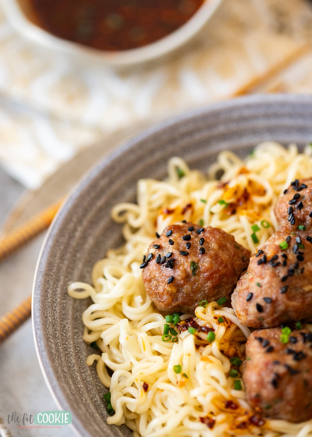 close up photo of asian meatballs on top of noodles. 