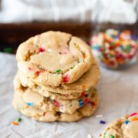Funfetti cookies stacked with sprinkles.