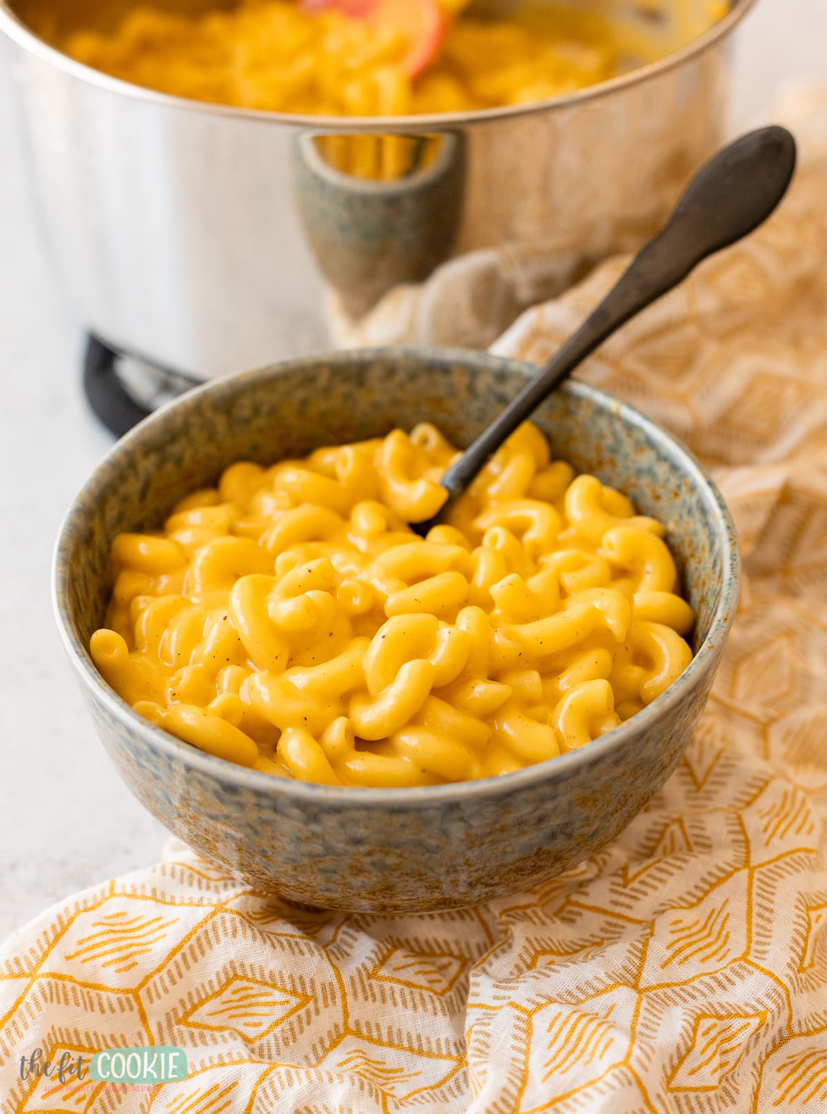 A speckled blue bowl full of mac and cheese.