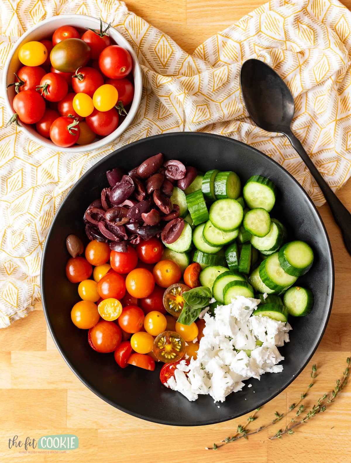 overhead photo of deconstructed greek salad in a black bowl. 