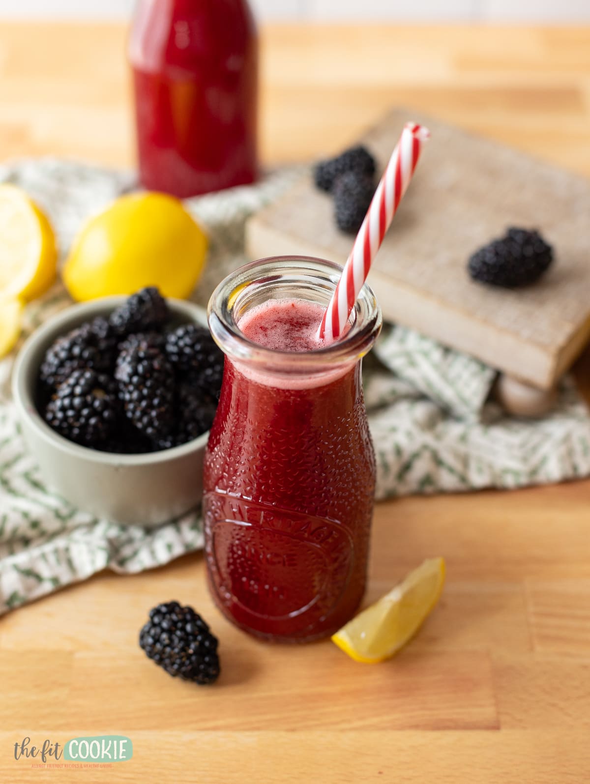 A refreshing glass of blackberry lemonade, garnished with lemon slices and juicy blackberries.