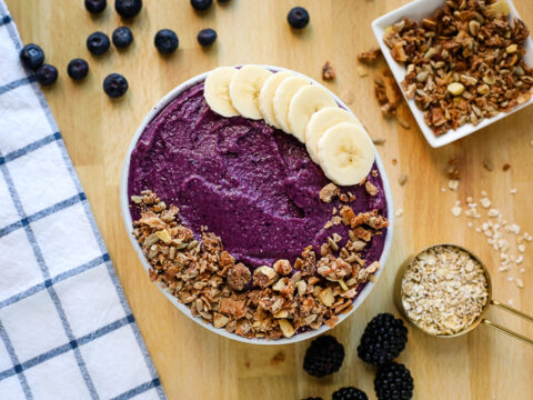 A bowl of blueberry granola with granola and bananas.