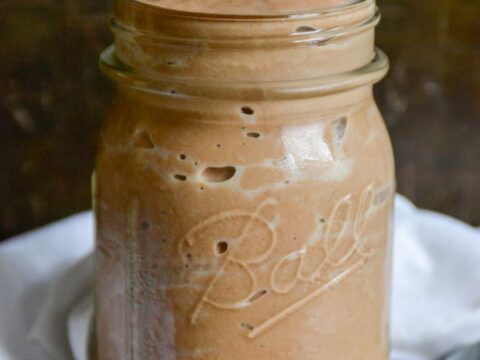 Chocolate mousse in a mason jar with a spoon.