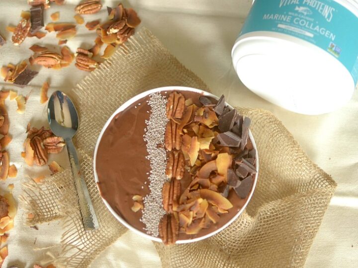 A bowl of chocolate and pecans with a spoon.