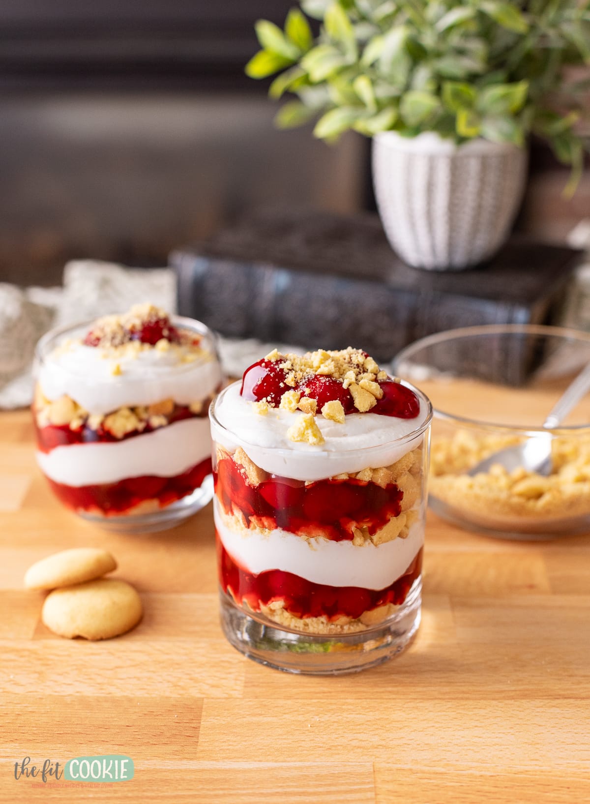 Gluten free cherry cheesecake trifle with in a glass on a wooden table.