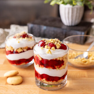 No-bake dairy free cherry cheesecake cups on a butcher block.