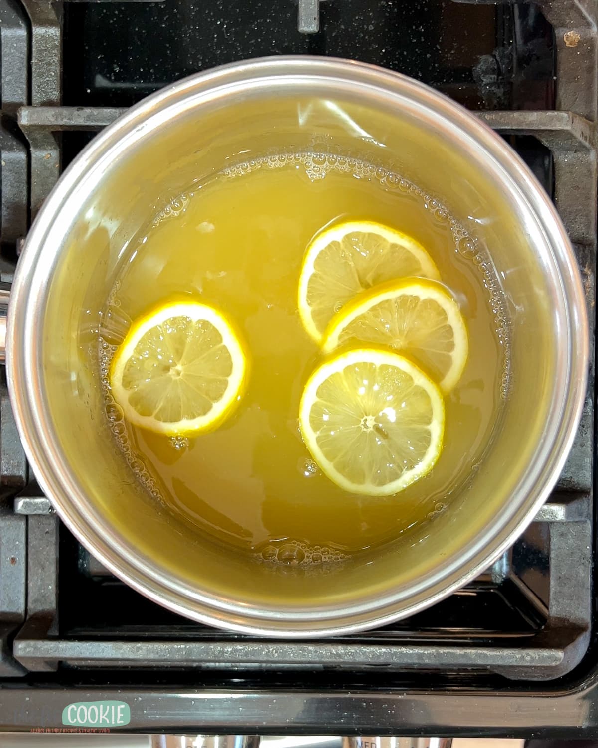 A saucepan with lemon juice and lemon slices on the stove. 