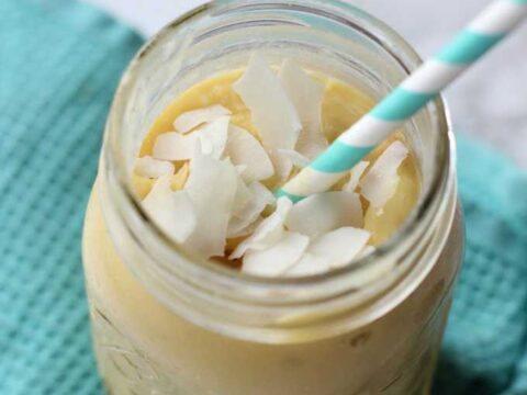 A smoothie in a jar with coconut shavings on top.