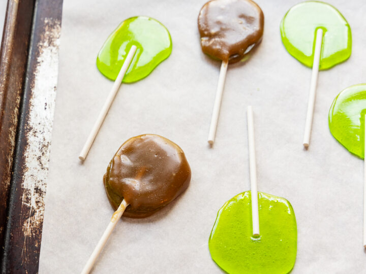 Caramel apple suckers on a baking sheet.