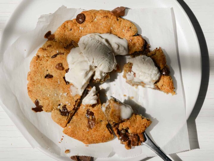 A cookie with ice cream on a plate.