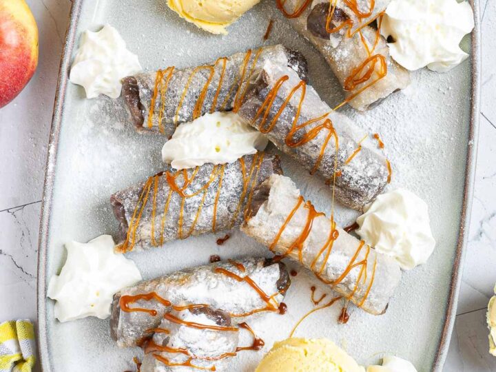 A plate topped with ice cream and apple fritters.