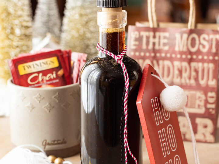 A bottle of hot cocoa sitting on a table next to a christmas tree.