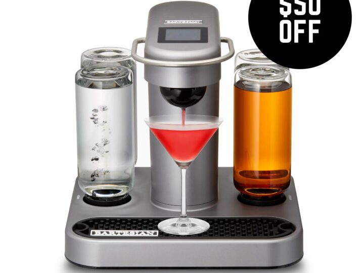 A cocktail maker with two glasses and a bottle of wine.