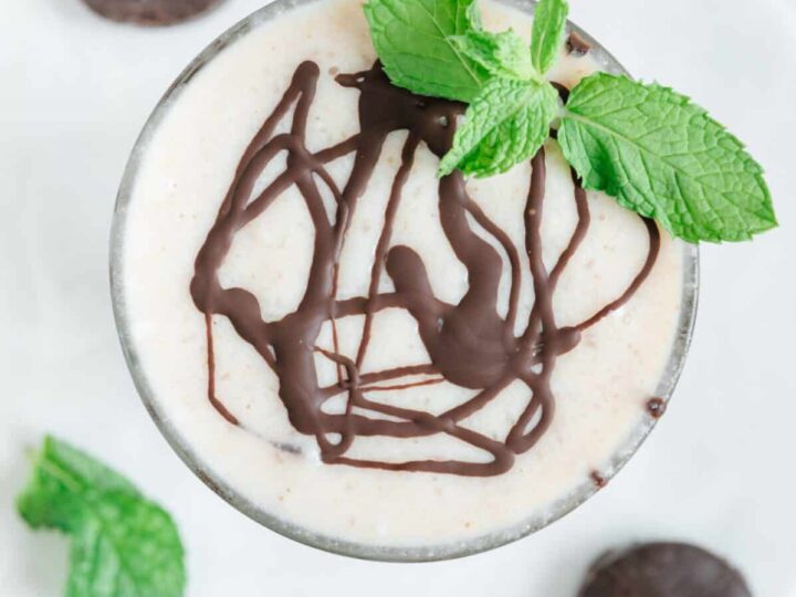 A chocolate mousse with mint leaves on a white plate.