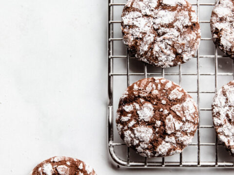 Chocolate crinkle cookies on a cooling rack.