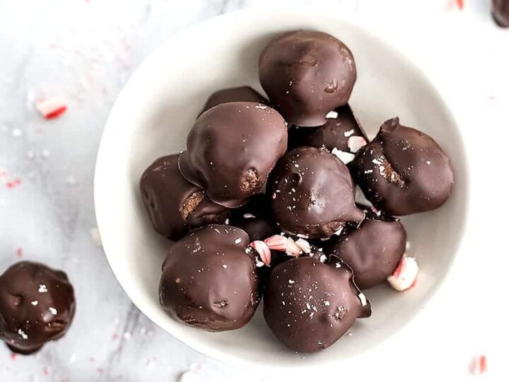 Chocolate covered candy canes in a white bowl.