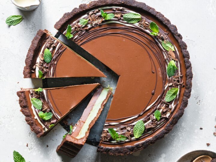 A chocolate mint tart with a slice taken out of it.