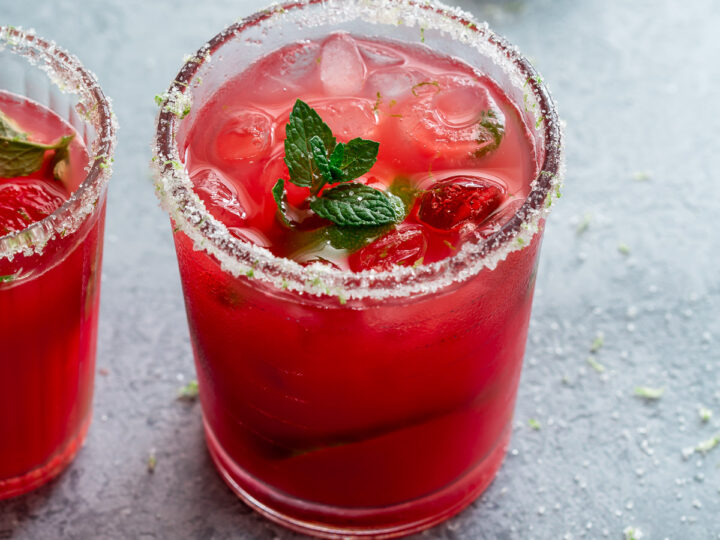 Two glasses of margarita with lime and mint.