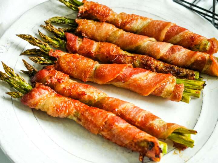 Asparagus wrapped in bacon on a plate.