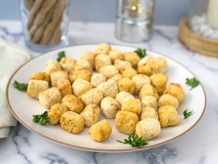 Cheesy tater tots on a white plate.