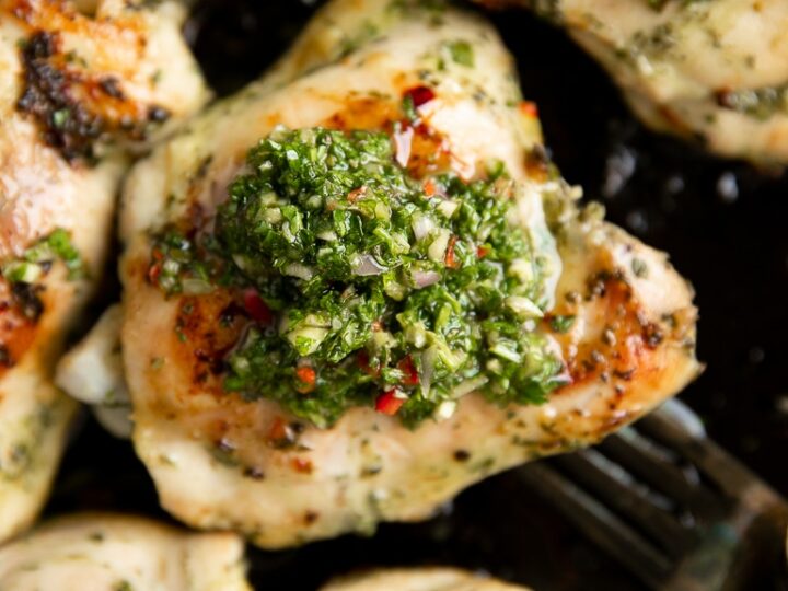 Chicken breasts with pesto sauce on a plate.