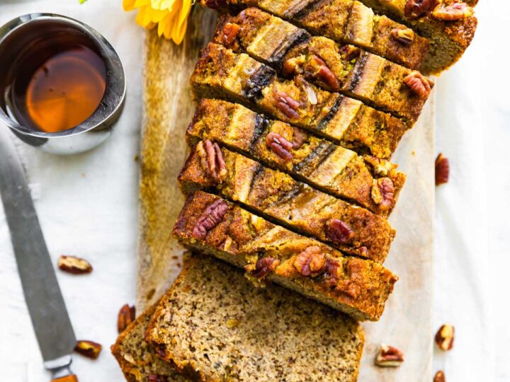 Banana bread with pecans on a cutting board.