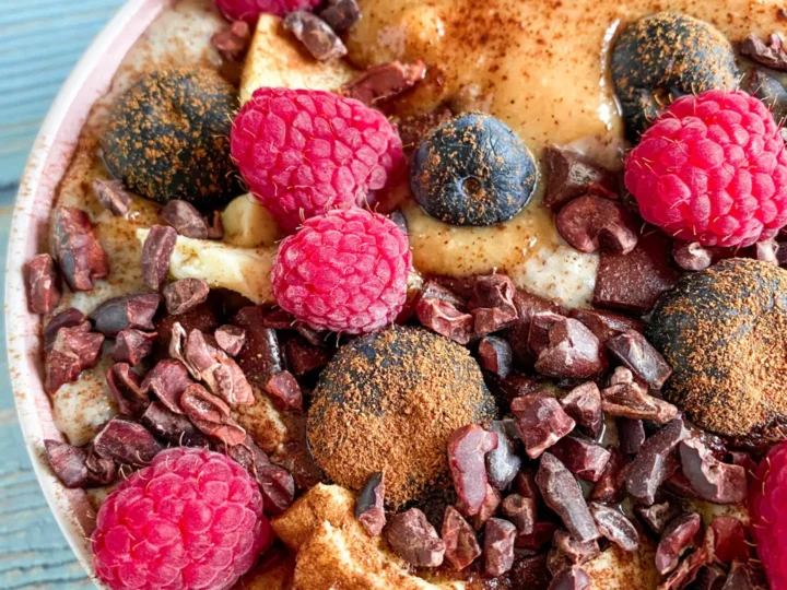 A bowl of dairy-free oatmeal with chocolate chips and raspberries, perfect for those seeking low carb recipes.