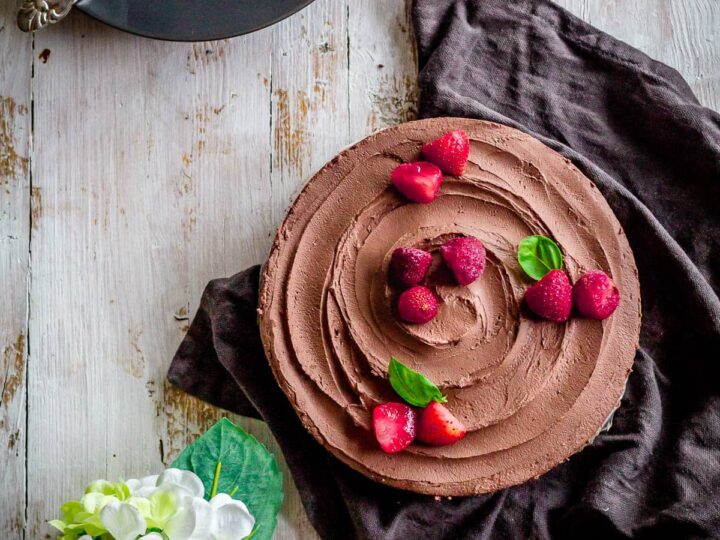 A chocolate pie with raspberries on top.