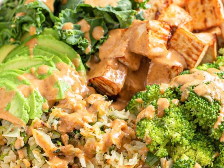 A bowl filled with broccoli, rice and tofu.