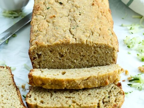 Zucchini bread on a cutting board with a knife.